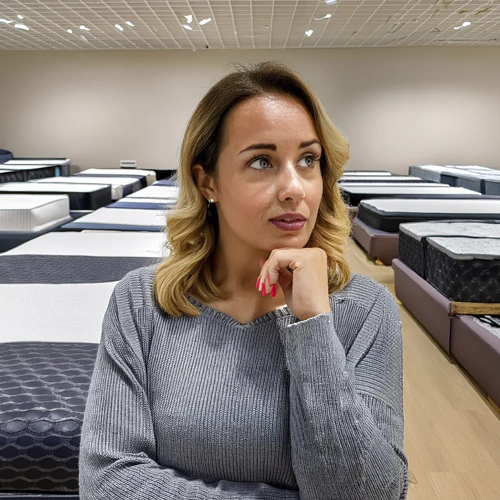 Slaaptyd Mites Persoon wat nadink oor matras keuses en algemene matras mites in 'n Slaaptyd vertoonlokaal.